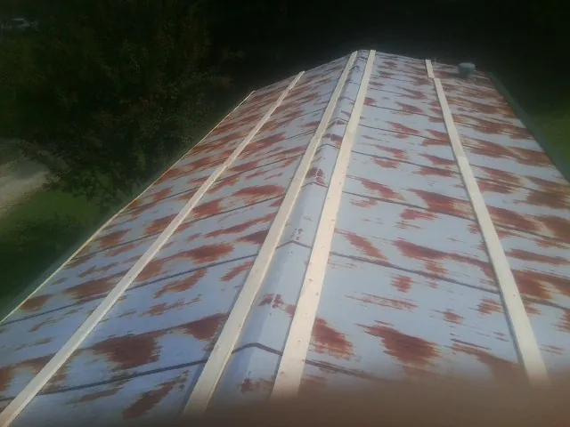 Rusted metal roof panels with new wood purlins before replacement — Storm Damage Roof Repair in Coward by Roofing Brothers
