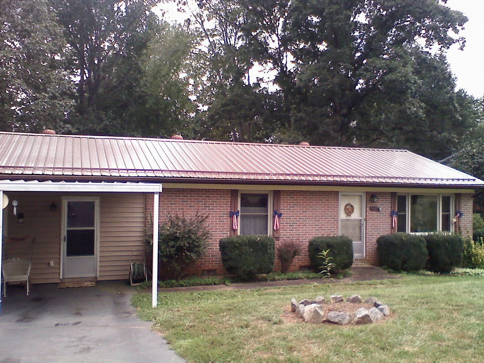 Bronze metal roof and carport on a brick ranch home — Roof Repair work by our crew in Coward